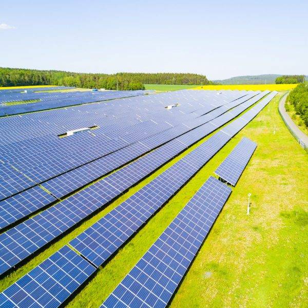 Aerial view of solar power plant. Solar farm system from above. Large photovoltaic power station next to the highway. Source of ecological renewable energy.